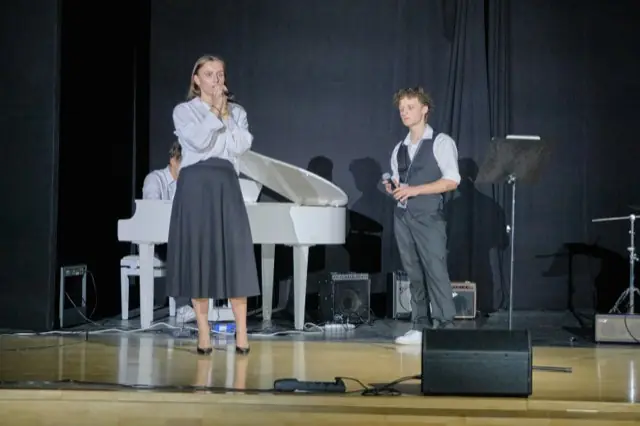 Wokalistka i wokalista przy białym fortepianie na scenie, 2. Salezjański Koncert Charytatywny w Łodzi