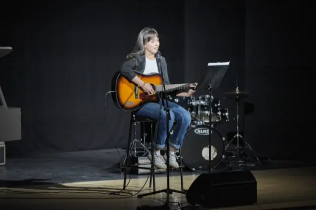 Uczennica z gitarą akustyczną podczas solowego występu, edycja 2025